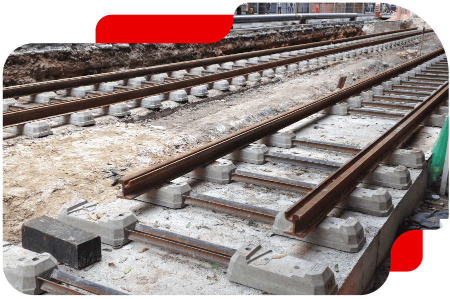 A team of engineers in hard hats reviewing blueprints on a construction site.